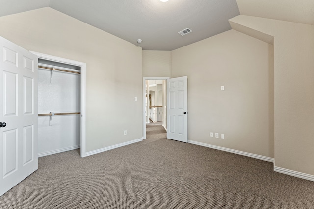 unfurnished bedroom with vaulted ceiling, carpet floors, visible vents, and baseboards