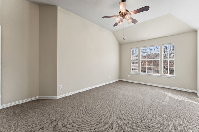 spare room featuring lofted ceiling, carpet flooring, a ceiling fan, and baseboards