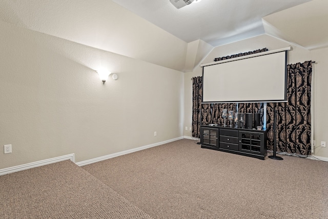 cinema room with vaulted ceiling, carpet, and baseboards