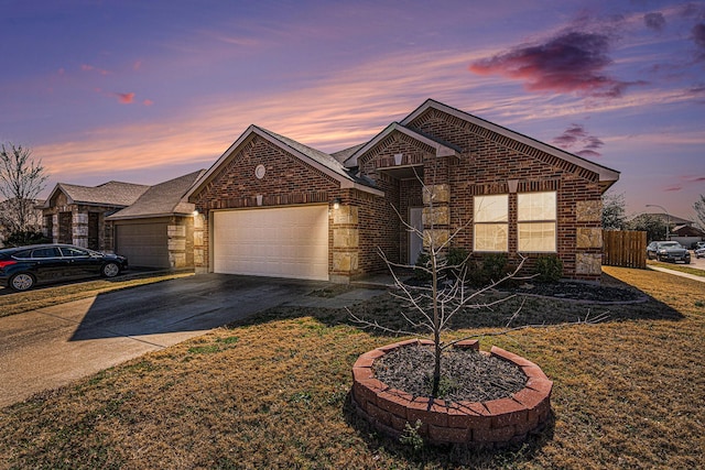 view of front of home featuring an attached garage, a yard, concrete driveway, and brick siding