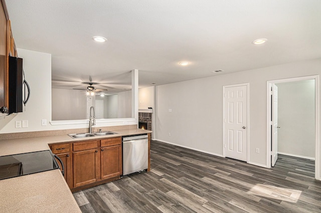 kitchen featuring dark wood-style flooring, brown cabinets, light countertops, appliances with stainless steel finishes, and a sink