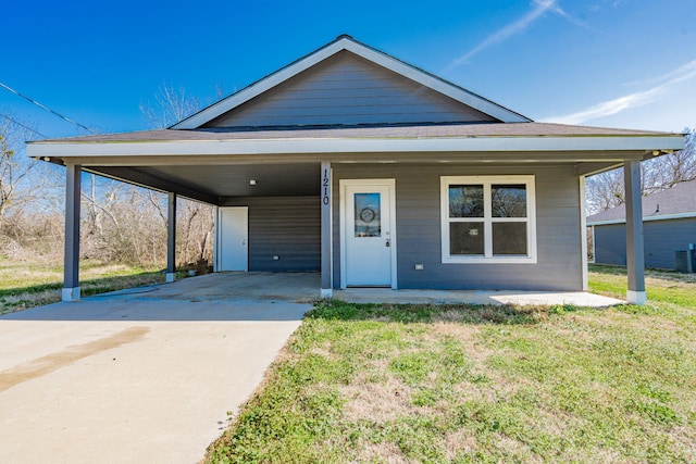 view of front facade with a carport, central AC, concrete driveway, and a front yard