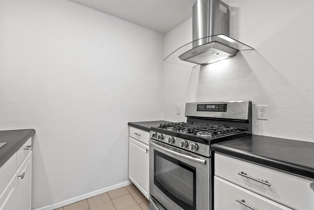 kitchen featuring dark countertops, white cabinets, ventilation hood, and stainless steel range with gas stovetop