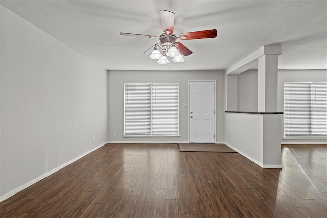 empty room featuring ceiling fan, wood finished floors, and baseboards