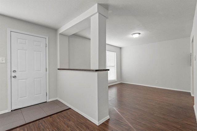 entryway with dark wood-style floors and baseboards