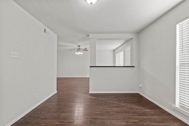 unfurnished room with a ceiling fan, baseboards, visible vents, and wood finished floors