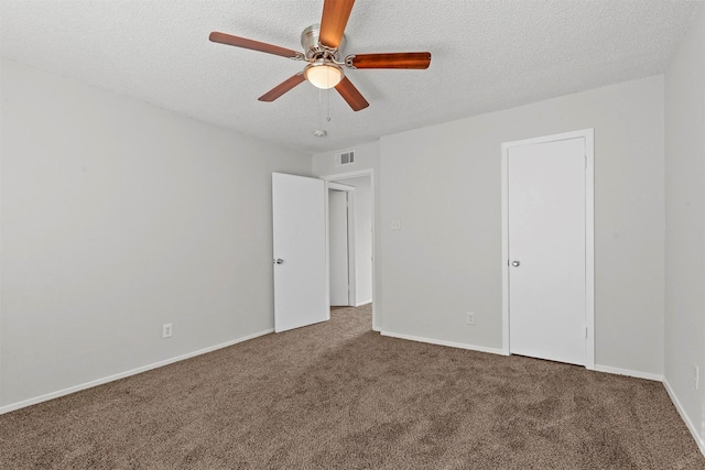 unfurnished bedroom featuring a textured ceiling, carpet floors, visible vents, and baseboards