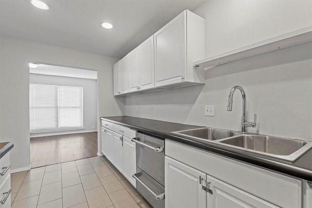 kitchen with recessed lighting, white cabinetry, a sink, and dark countertops