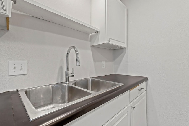 kitchen with white cabinetry and a sink