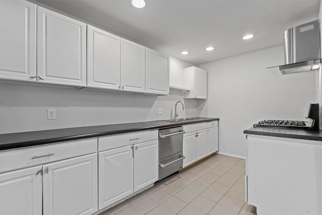 kitchen with dark countertops, white cabinets, and a sink