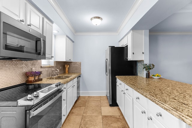 kitchen with stainless steel appliances, light stone counters, a sink, and white cabinetry