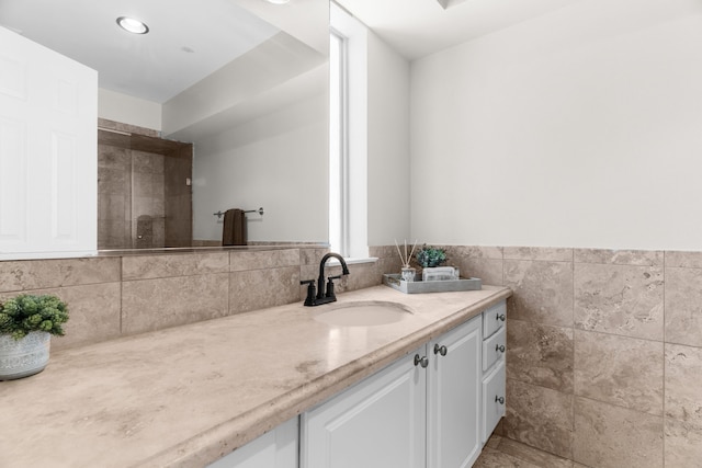 bathroom with tile walls, wainscoting, and vanity