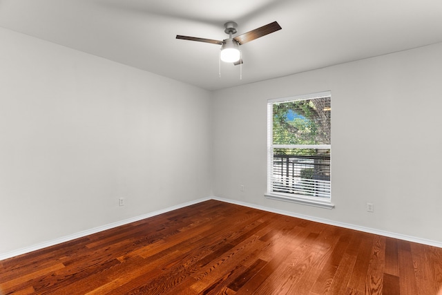 spare room featuring ceiling fan, baseboards, and wood finished floors