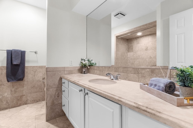 bathroom featuring a wainscoted wall, tile walls, vanity, and tile patterned floors