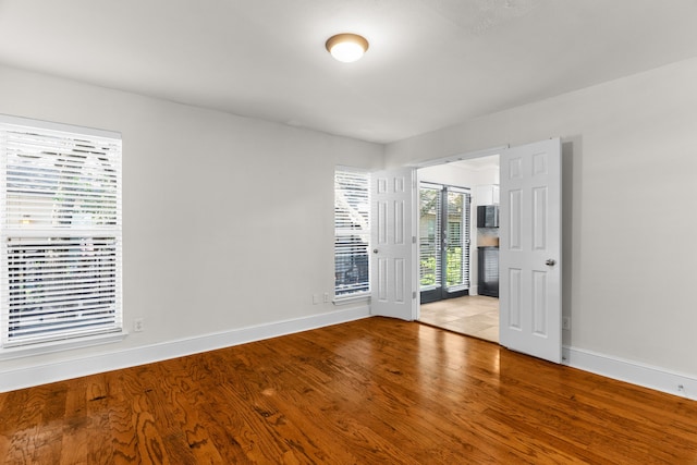 spare room with light wood-style flooring and baseboards