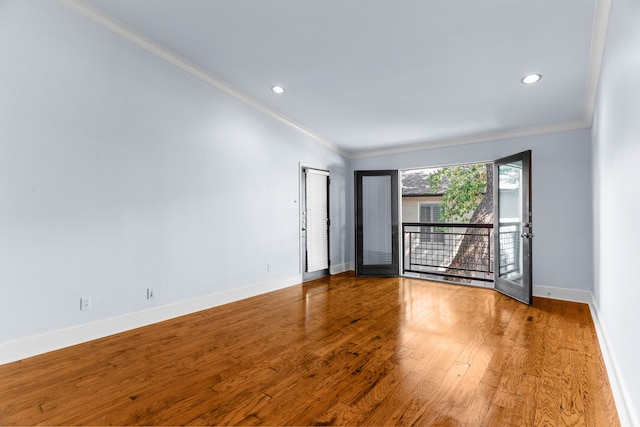 empty room featuring recessed lighting, crown molding, baseboards, and wood finished floors