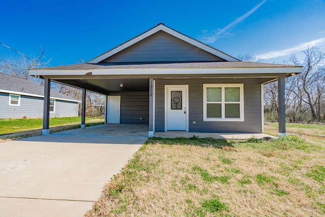 view of front of house featuring an attached carport, concrete driveway, and a front lawn