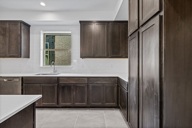 kitchen featuring light countertops, decorative backsplash, stainless steel dishwasher, light tile patterned flooring, and a sink