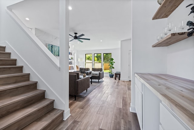 interior space featuring stairway, wood finished floors, a ceiling fan, and recessed lighting