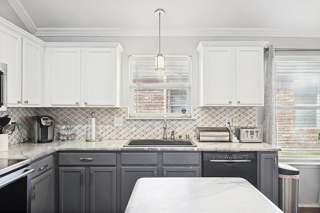 kitchen with stainless steel appliances, white cabinets, a sink, and decorative light fixtures