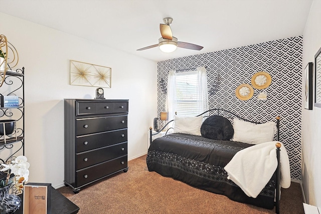 bedroom with an accent wall, carpet floors, a ceiling fan, and baseboards