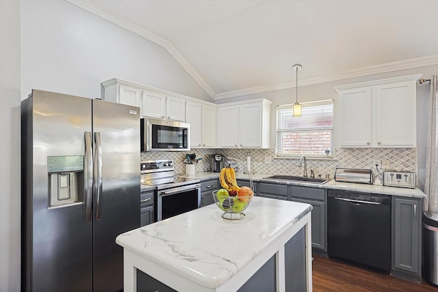 kitchen with a center island, pendant lighting, appliances with stainless steel finishes, white cabinets, and vaulted ceiling