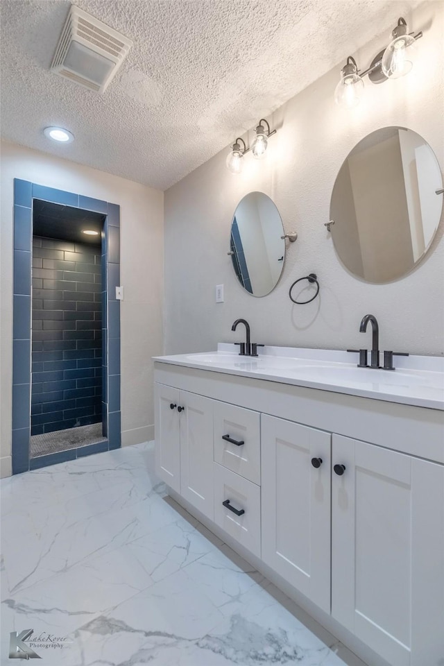 full bathroom featuring marble finish floor, visible vents, and a sink