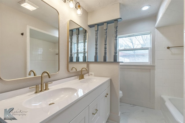 full bath featuring a textured ceiling, marble finish floor, a sink, and toilet