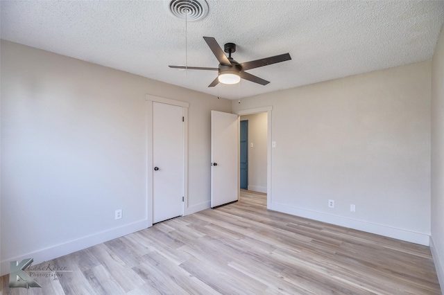 unfurnished bedroom with visible vents, light wood-style floors, a ceiling fan, a textured ceiling, and baseboards