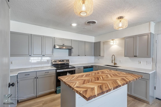 kitchen with a kitchen island, appliances with stainless steel finishes, gray cabinets, under cabinet range hood, and a sink