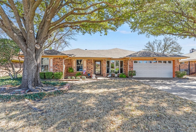 single story home featuring driveway, brick siding, roof with shingles, and an attached garage