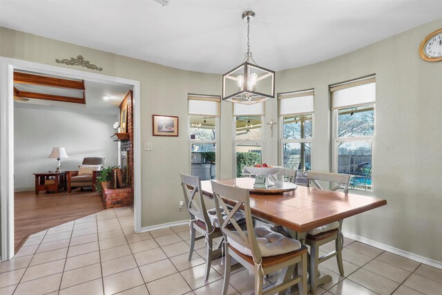 dining area featuring light tile patterned floors, a chandelier, and baseboards