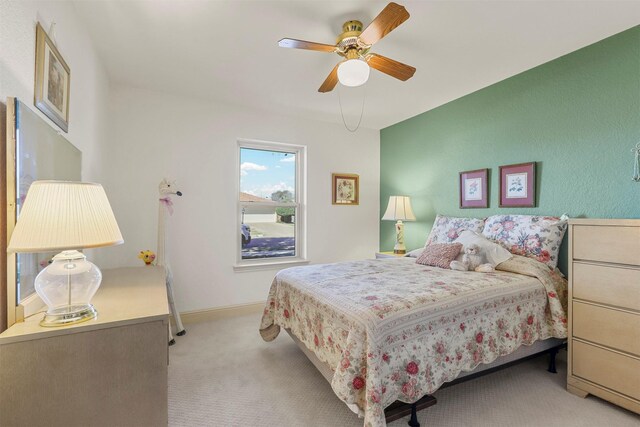 bedroom with light carpet, baseboards, and a ceiling fan