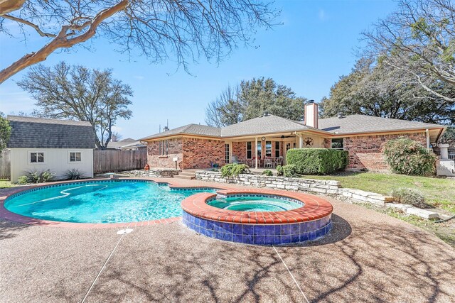 view of pool with a fenced in pool, fence, an in ground hot tub, an outdoor structure, and a patio area