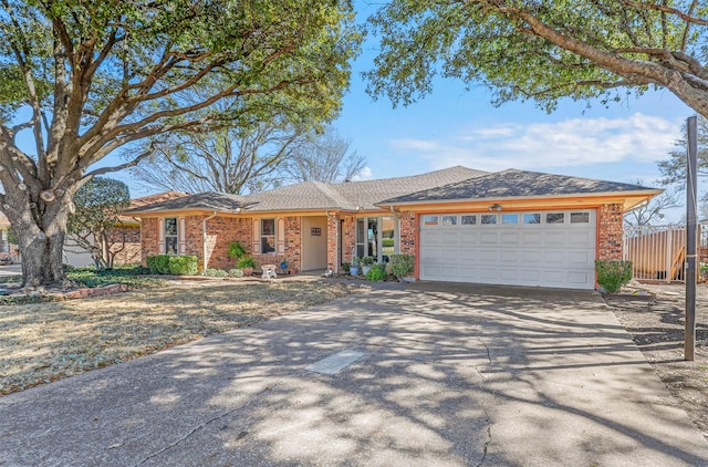 ranch-style house with an attached garage, fence, brick siding, and driveway