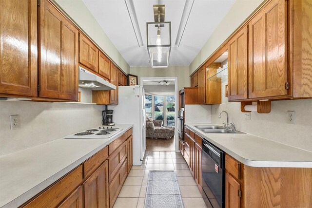 kitchen with white appliances, light countertops, under cabinet range hood, and a sink