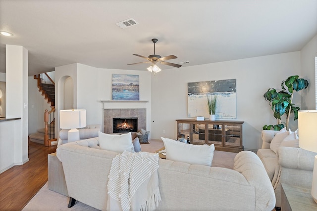 living area with stairs, a fireplace, wood finished floors, and visible vents