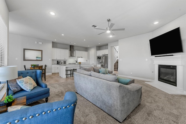 living room featuring ceiling fan, baseboards, a fireplace with flush hearth, and recessed lighting