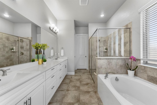 bathroom featuring double vanity, visible vents, a garden tub, a shower stall, and a sink