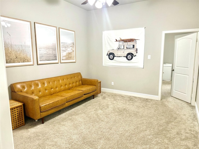 living room with light carpet, a ceiling fan, and baseboards