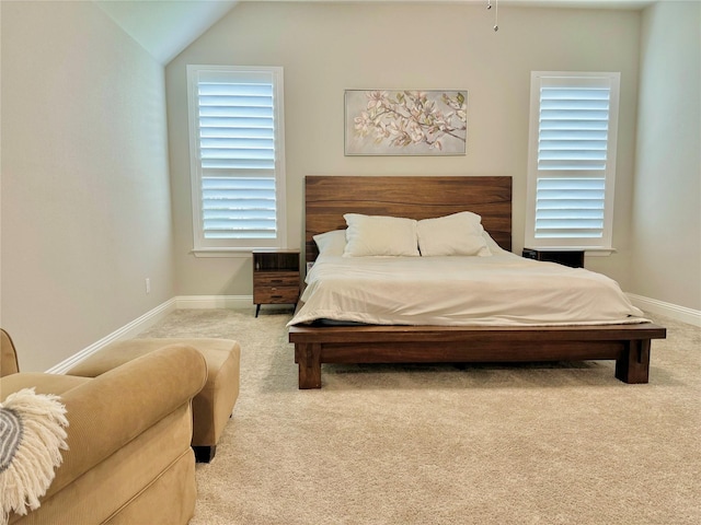 carpeted bedroom featuring lofted ceiling and baseboards