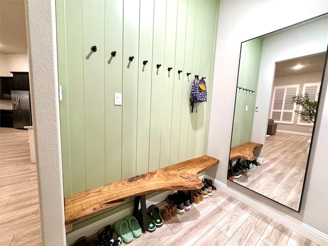 mudroom featuring baseboards and light wood finished floors