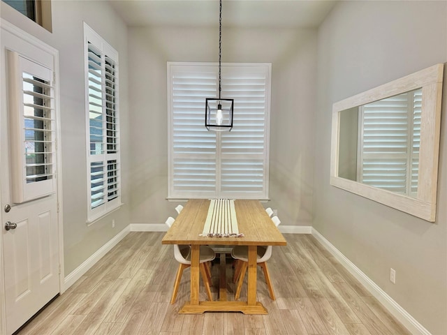 dining space with light wood-style flooring and baseboards