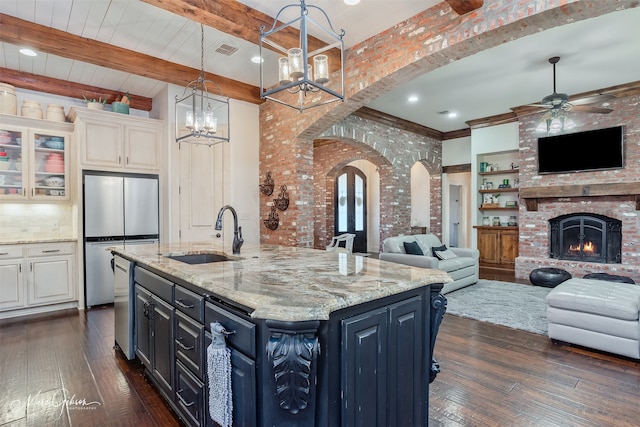 kitchen featuring visible vents, arched walkways, open floor plan, and a sink