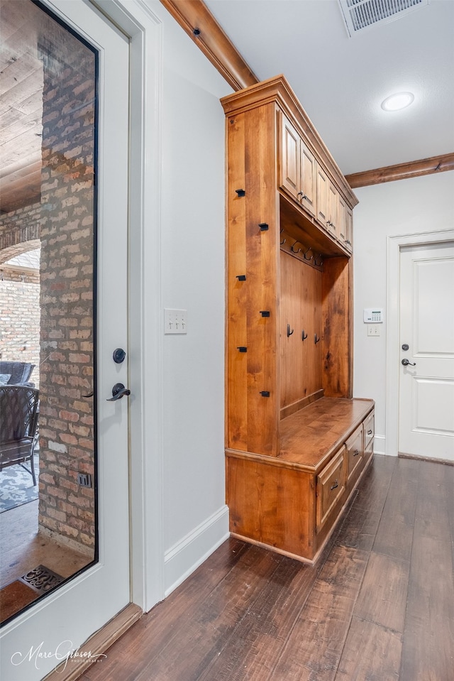 mudroom with visible vents, dark wood-type flooring, baseboards, and ornamental molding