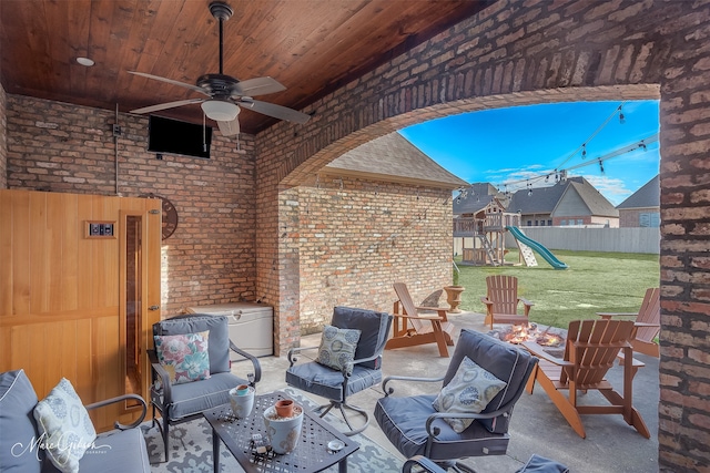 view of patio featuring a playground, fence, and ceiling fan