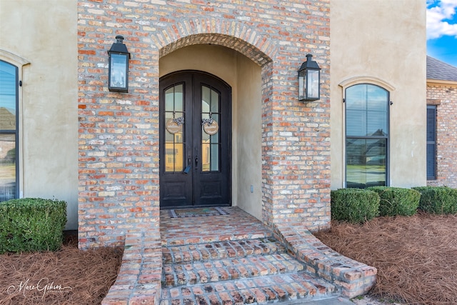 view of exterior entry with french doors and brick siding