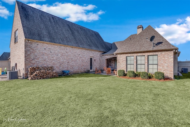 view of front of house with cooling unit, a patio area, brick siding, and a chimney