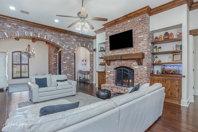 living area featuring visible vents, arched walkways, a fireplace, and hardwood / wood-style flooring