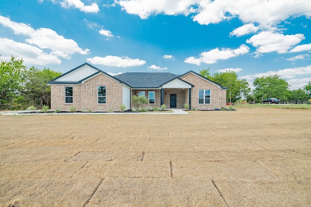 view of front facade with brick siding and a front lawn